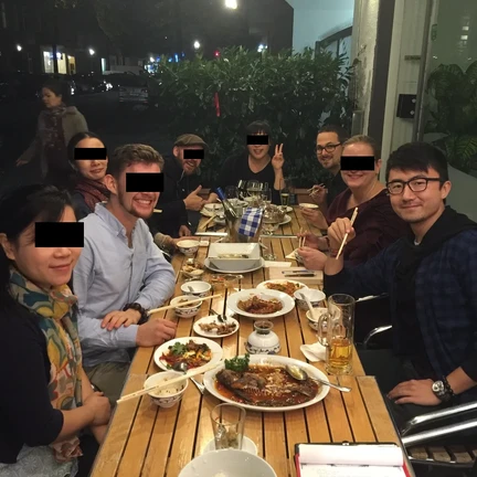 people at an outside table at a sichuang restaurant enjoying spicy food